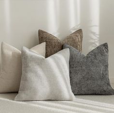 four pillows sitting on top of a white couch