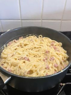 a pan filled with pasta sitting on top of a stove