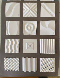 several different types of paper are arranged on a sheet of gray and white material with lines, shapes, and curves