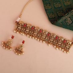 Description : Introducing our striking silver choker set from the Mandira collection, featuring the divine Goddess Lakshmi motif nestled within a temple-inspired design. Embellished with semi-precious coral stones and adorned with cluster pearl drops, this meticulously handcrafted choker set exudes elegance and charm. Whether for wedding festivities, soirées, or other memorable occasions, this captivating set is sure to make a statement. Product Information : Materials used : 925 Silver with Ant Luxury Temple Jewelry Bridal Sets, Traditional Luxury Choker For Diwali, Luxury Ceremonial Choker For Diwali, Coral Temple Jewellery, Luxury Hand Set Temple Jewelry Sets, Luxury Temple Necklace For Reception During Diwali, Luxury Festive Temple Jewelry For Wedding And Engagement, Luxury Temple Jewelry Earrings For Festive Season, Luxury Round Temple Jewelry Sets