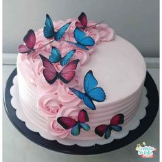 a cake with pink frosting and blue butterflies on it