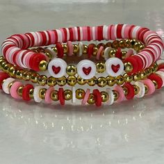 three bracelets with red, white and gold beaded hearts on each strander