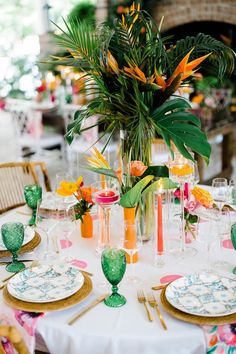 the table is set with colorful dishes and place settings