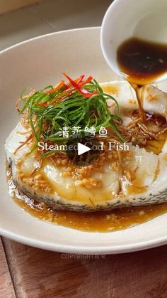 an image of steamed fish being drizzled with sauce