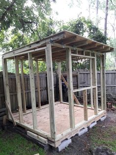 a small wooden structure in the middle of a yard