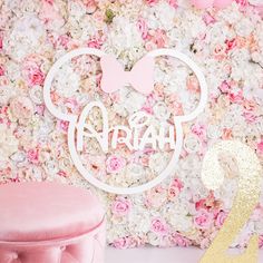 a pink and gold birthday party with minnie mouse cake topper on the table, next to a floral backdrop