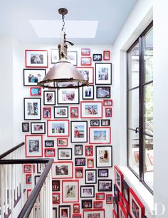 a staircase with pictures on the wall and a light fixture