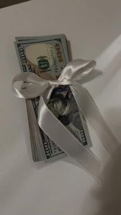 a bundle of money tied to a white ribbon