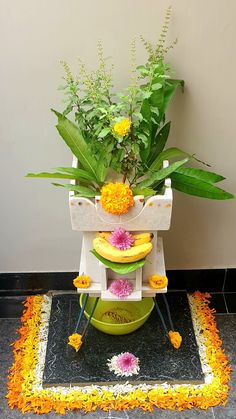 a potted plant sitting on top of a stand with yellow flowers and green leaves