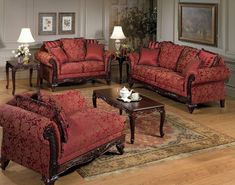 a living room filled with red couches and chairs