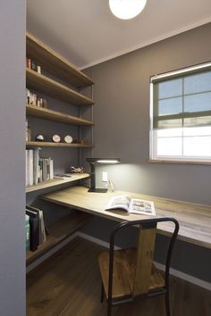 a desk with a lamp and books on it in front of a book shelf filled with books