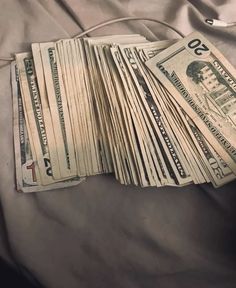 a pile of money sitting on top of a bed