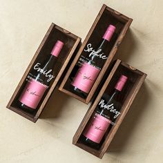 three empty wine bottles in wooden boxes on a table