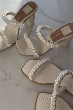 three pairs of shoes with pearls on them