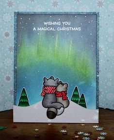 a handmade christmas card with a hippo holding a scarf and the words wishing you a magical christmas