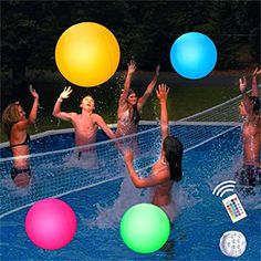 several people are playing volleyball in the pool at night with lights on and remotes nearby