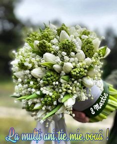 a bouquet of white flowers is being held by someone