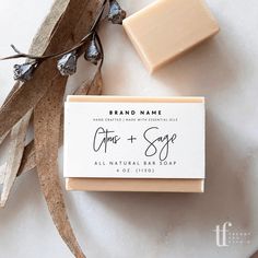 a bar of soap sitting on top of a white surface next to some brown leaves