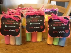 four candles with valentine's day messages on them sitting in front of a chair