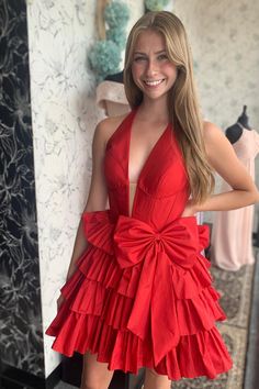 Crafted from high-quality taffeta, this dress features a sophisticated A-line shape in a bold red hue. The halter neck and tiered ruffle skirt create a playful and feminine look, while the above-knee length adds a touch of elegance. Completed with a charming bow detail at the waist and a convenient zip-up back, this dress is the perfect addition to your wardrobe. SKU: 3725 Taffeta material A-line silhouette Red color Halter neck Tiered ruffle skirt Above knee length Bow on the waist Zip-up back Halter Neck Homecoming Dress, Dresses With Bow, Dress Satin Bridesmaid, Bridesmaid Dresses Satin, Maternity Bridesmaid Dresses, Short Homecoming Dresses, Satin Homecoming Dress, Tiered Ruffle Skirt, Tiered Ruffle Dress