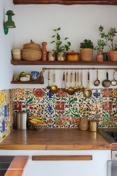 a kitchen counter with pots and pans hanging on the wall next to an oven