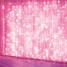 a pink curtain with lights on it in front of a wooden floor