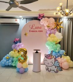 balloon arch with unicorns, stars and balloons in front of the sign for luna medical - vera