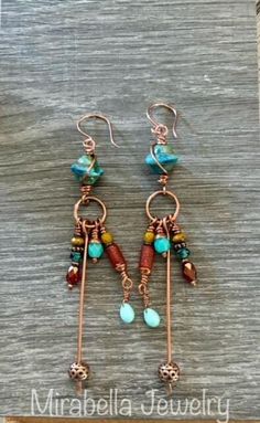 Pretty blue czech glass beads are wire wrapped and have a copper ring below with lots of colorful Czech glass and copper beads dangling from. Copper ear wires and a  protective coating finish off these beautiful earrings. Total length is just over 4" long. Bohemian Hand-wrapped Wire Earrings, Bohemian Hand Wrapped Wire Earrings, Bohemian Hand Wrapped Copper Earrings, Bohemian Wire Wrapped Copper Earrings, Bohemian Hand-wrapped Copper Wire Earrings, Bohemian Hand Wrapped Copper Wire Earrings, Unique Beaded Dangle Earrings, Bohemian Wire Dangle Jewelry, Unique Copper Beaded Dangle Earrings