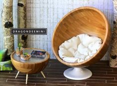 a wooden chair sitting next to a small table on top of a wooden floor covered in white fabric