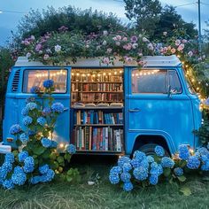 an old vw bus is decorated with flowers, books and fairy lights in the back