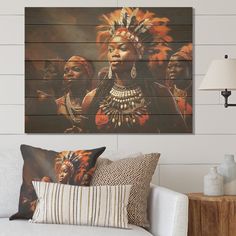 a living room scene with focus on the couch and wall art depicting native american women