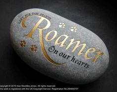 a rock with the words roamer on it and paw prints painted on it's side