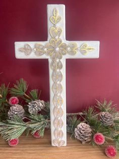 a wooden cross with pine cones on the side