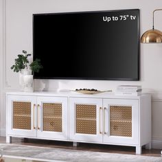 a flat screen tv mounted to the side of a white entertainment center with wicker doors