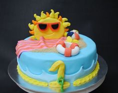 a birthday cake decorated to look like a beach scene with sun and sunglasses on it