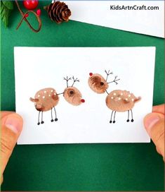 someone is holding up a card with two reindeers on it