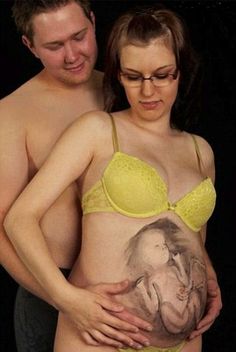 a pregnant woman in a yellow bra with her belly painted to look like an elephant