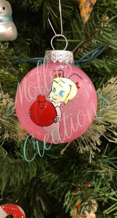 a pink ornament hanging from a christmas tree