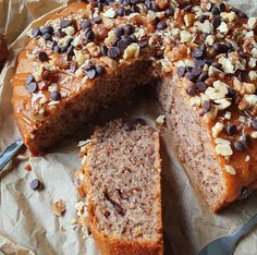 a cake that has been cut into pieces and is sitting on wax paper next to a fork