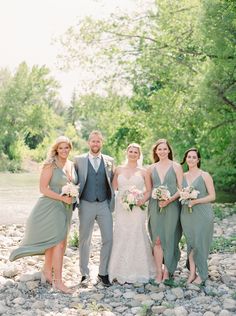 a group of people standing next to each other in front of a body of water