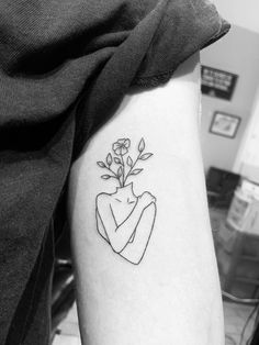 a woman's arm with a small flower in the shape of a heart on it