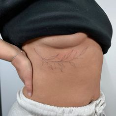 a woman's stomach with a small tattoo on her lower back and the bottom part of her belly