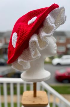 a white mannequin head wearing a red hat