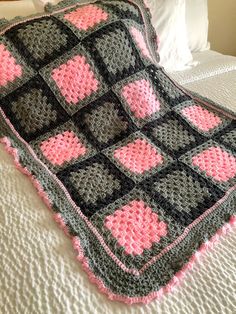 a crocheted blanket is laying on a bed