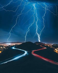 lightning strikes over a city at night time