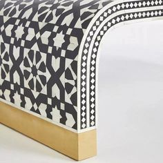 a white and black bench with gold trim