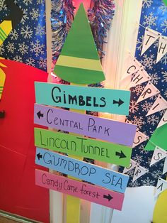 a colorful christmas tree made out of paper and some signs on the front door for children to use