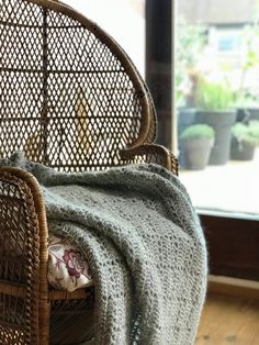 a wicker chair with a blanket on it