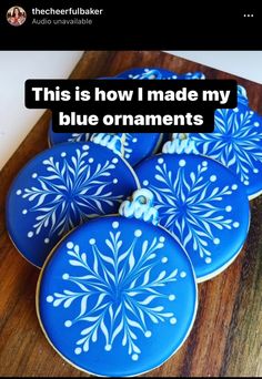 blue decorated cookies with white snowflakes are on a wooden board and the caption reads, this is how i made my blue ornaments