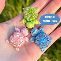 three small crocheted fish sitting on top of each other in the palm of someone's hand